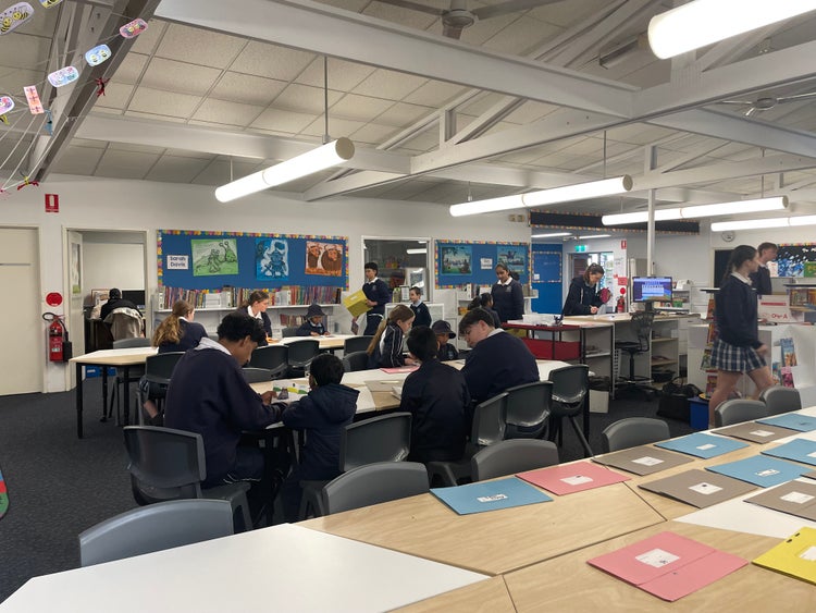 several students working at a desk in the school library