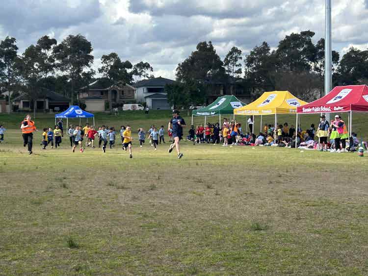students running during sports carnival showing school house colours