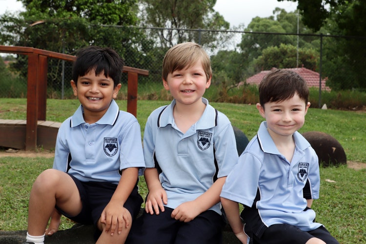 3 students sitting outside on playground