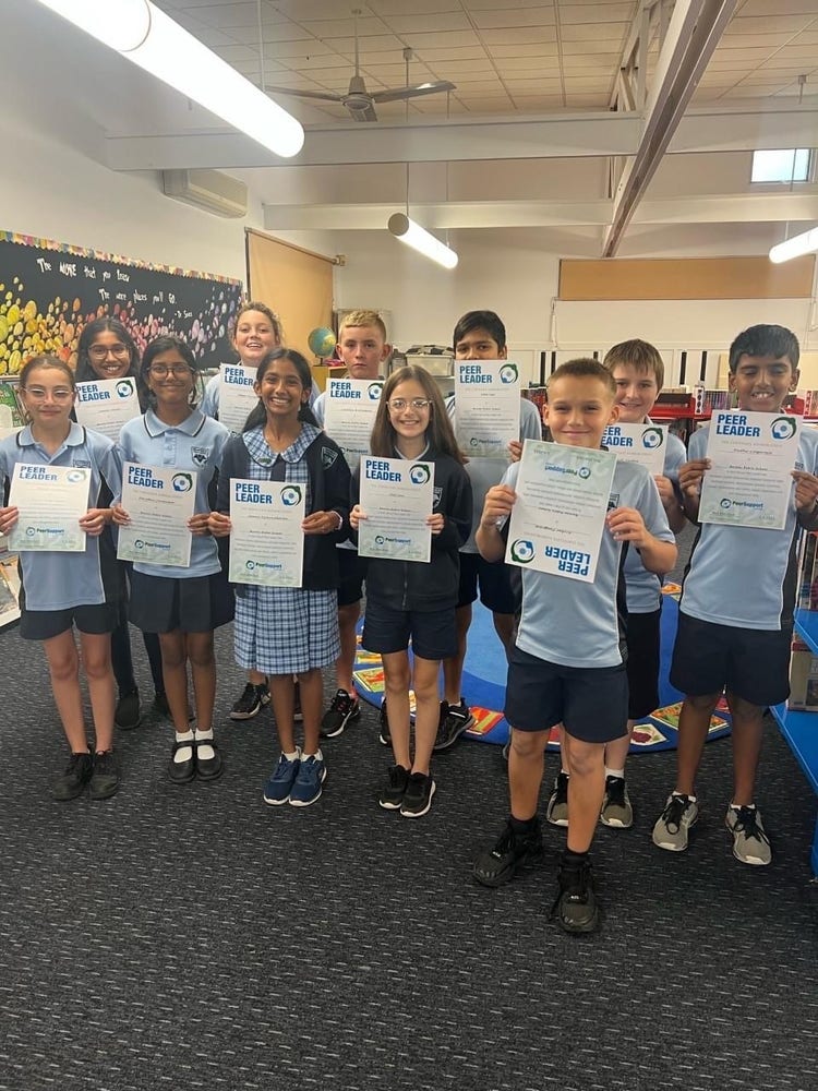 11 senior students showing certifcates and celebrating the completion of peer support